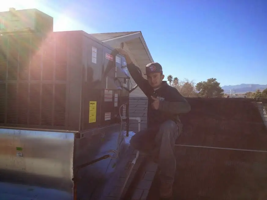 HVAC technician performing Air Duct Repair on a rooftop unit in Chestertown